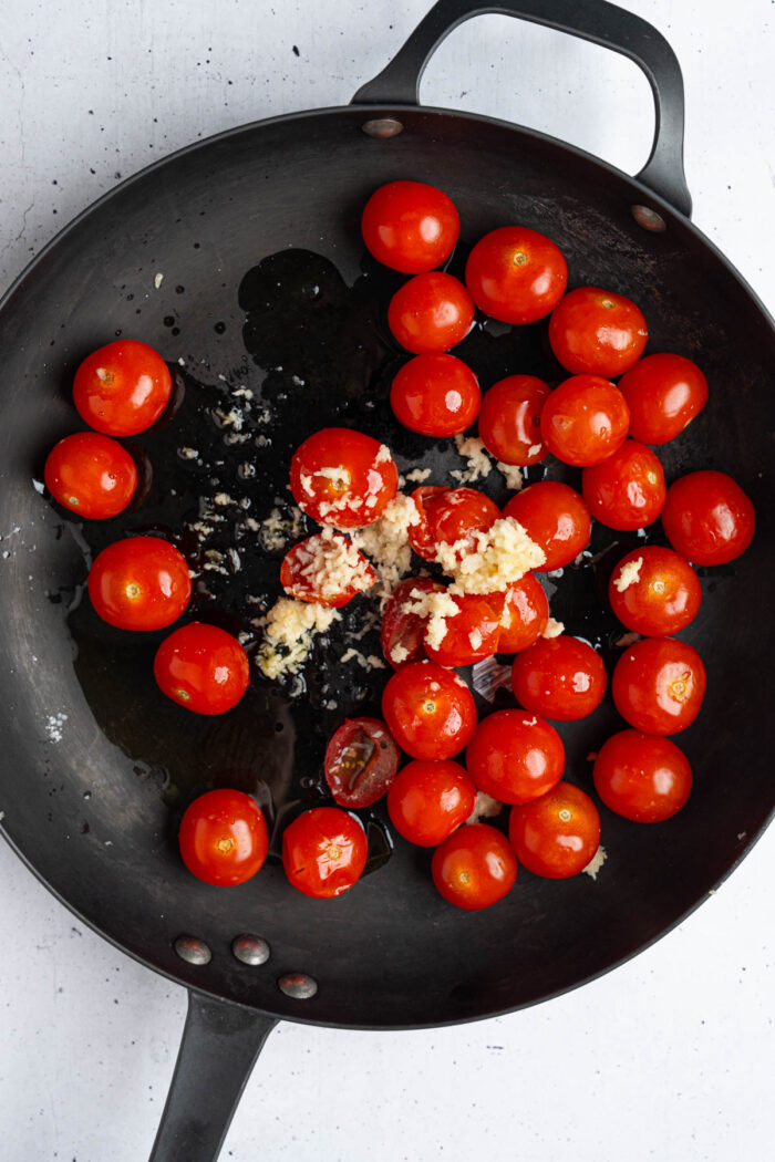 Cherry tomatoes and garlic in a large skillet with olive oil.