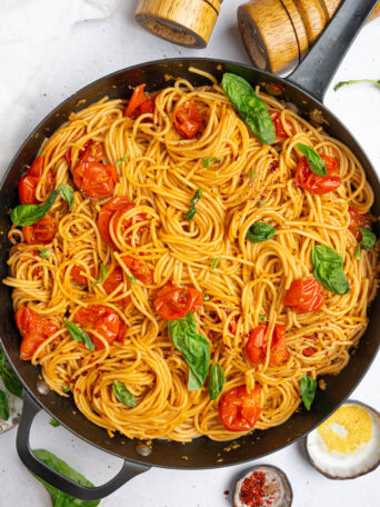 A large skillet photographed from the top, full to the brim of one pot chery tomato basil pasta.