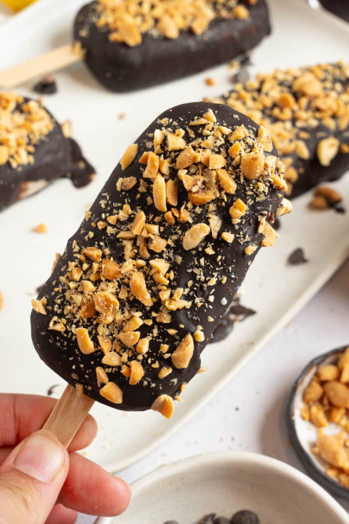 A close up of a homemade vegan Magnum with crushed peanuts.