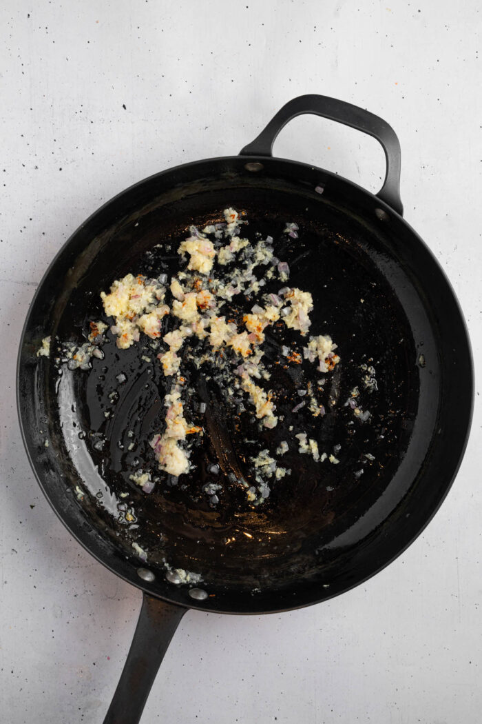 Shallot, ginger and garlic sauted with oil in a frying pan.