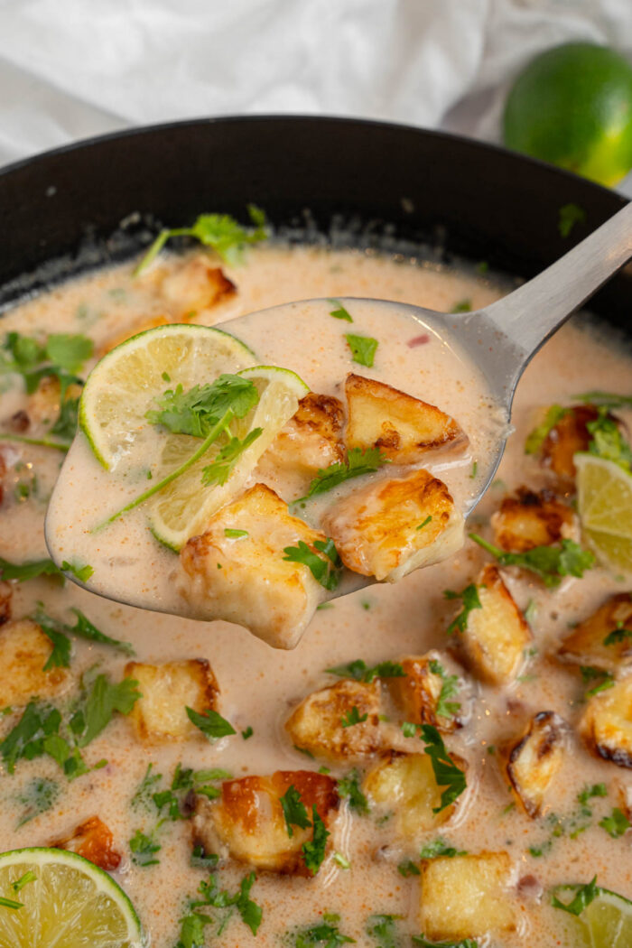 A spoonful of coconut lime tofu in the foreground of the photo.