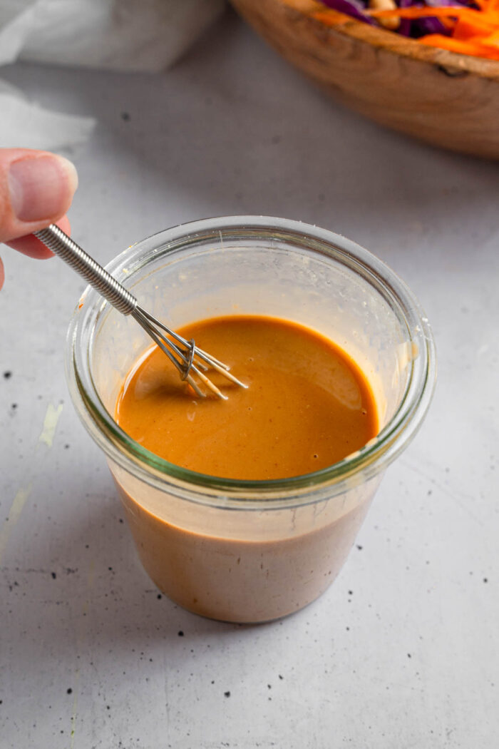 Peanut salad dressing whisked in a small jar.