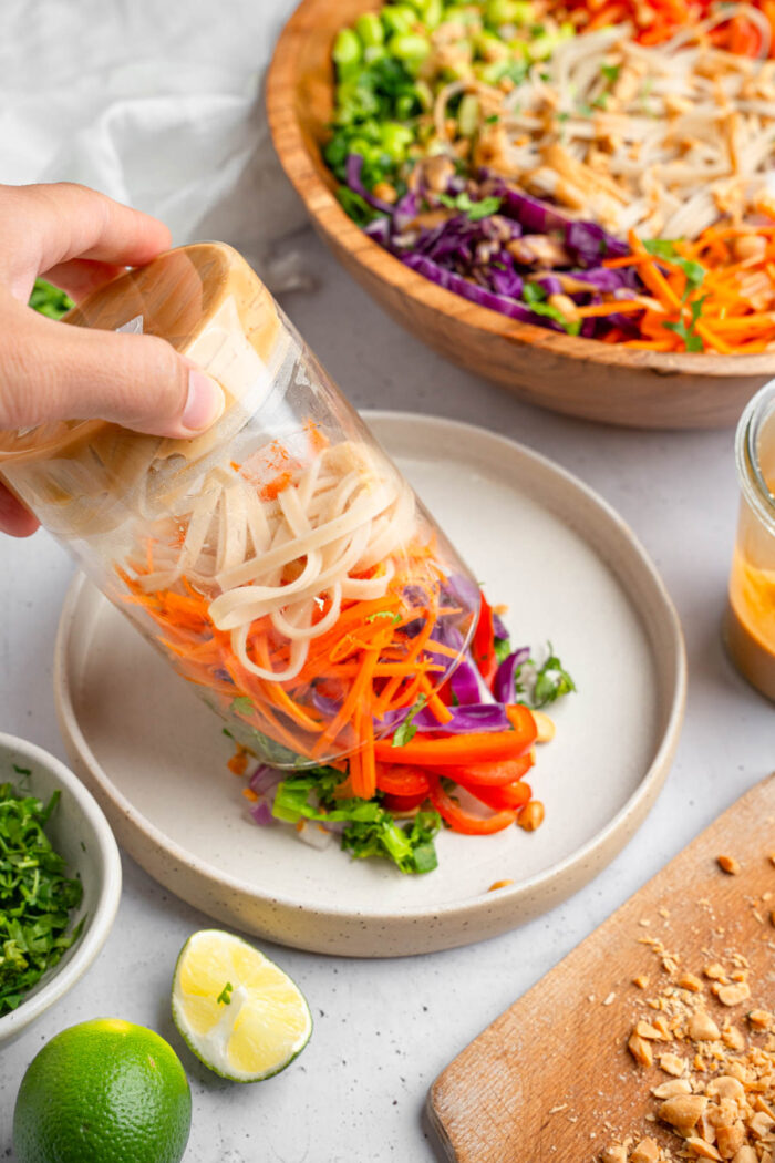 Meal prep version of Thai noodle salad being emptied to the plate.