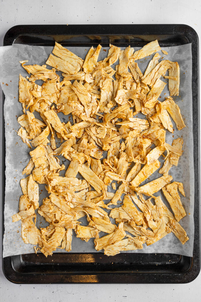 Marinated tofu laid out on a lined baking sheet.