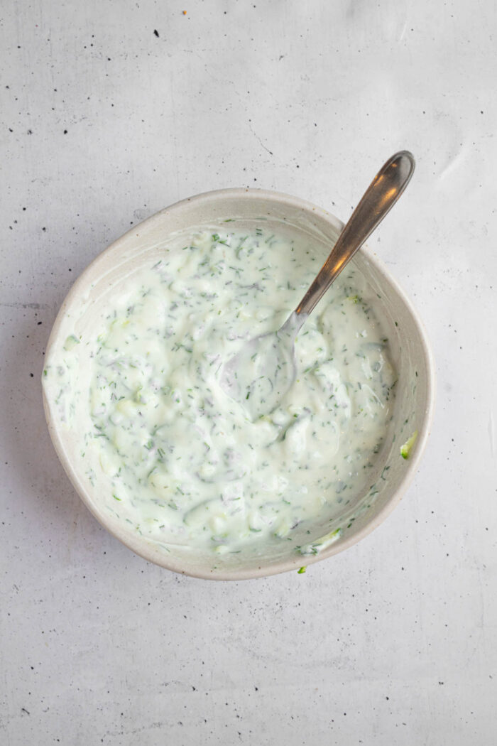 Vegan tzatziki sauce mixed up in a small bowl.