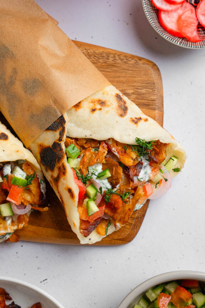 Close up shot of vegan shawarma with plant-based filling and lots of vegetables.