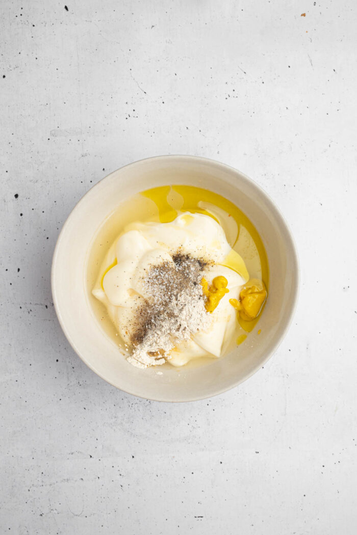 Creamy dressing for the dill pickle pasta salad being mixed up in a small bowl.