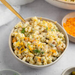 Dill Pickle pasta Salad in a large serving bowl with a spoon sticking out of the bowl.