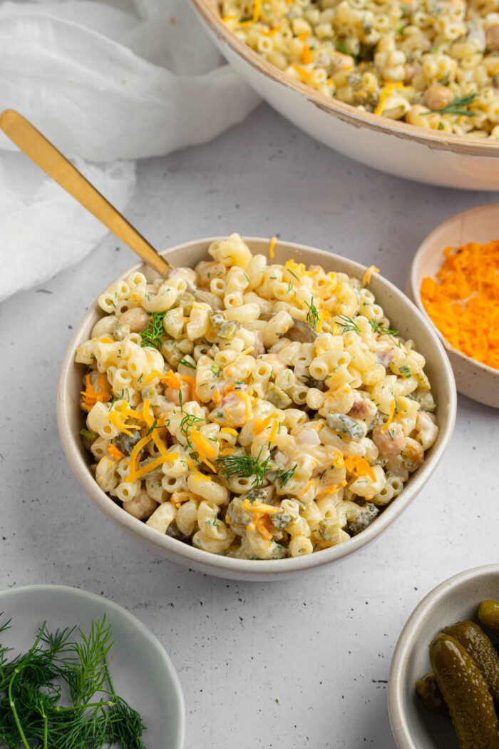 Dill Pickle pasta Salad in a large serving bowl with a spoon sticking out of the bowl.