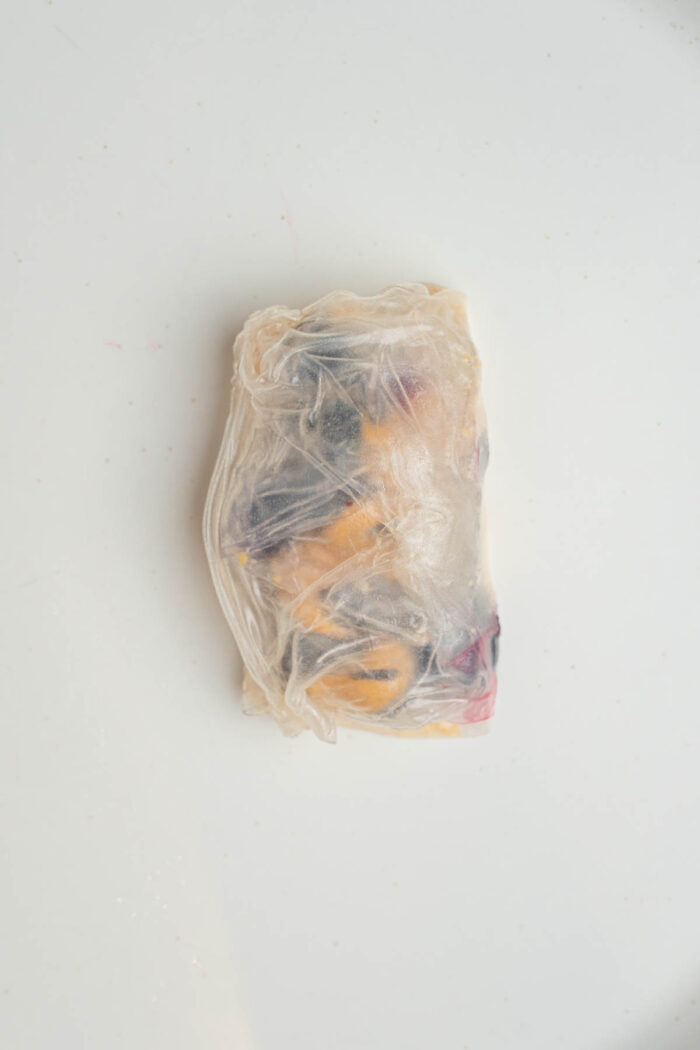 Rice paper wrapped around the ingredients to create a small sweet dumpling.