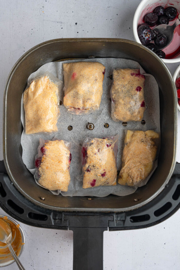 Sweet rice paper dumplings placed into the lined drawer of the air fryer.