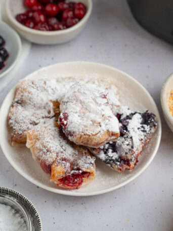Sweet rice paper dumplings finished with powdered sugar and set on a plate.