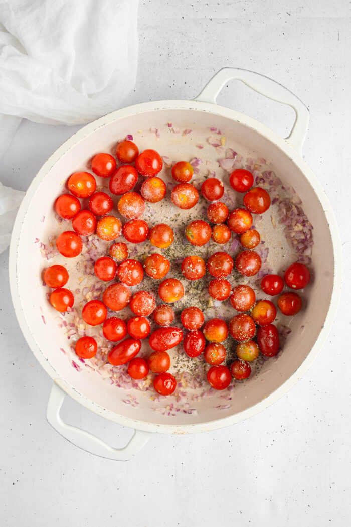 Cherry tomatoes added to the pan and cooked until they burst.