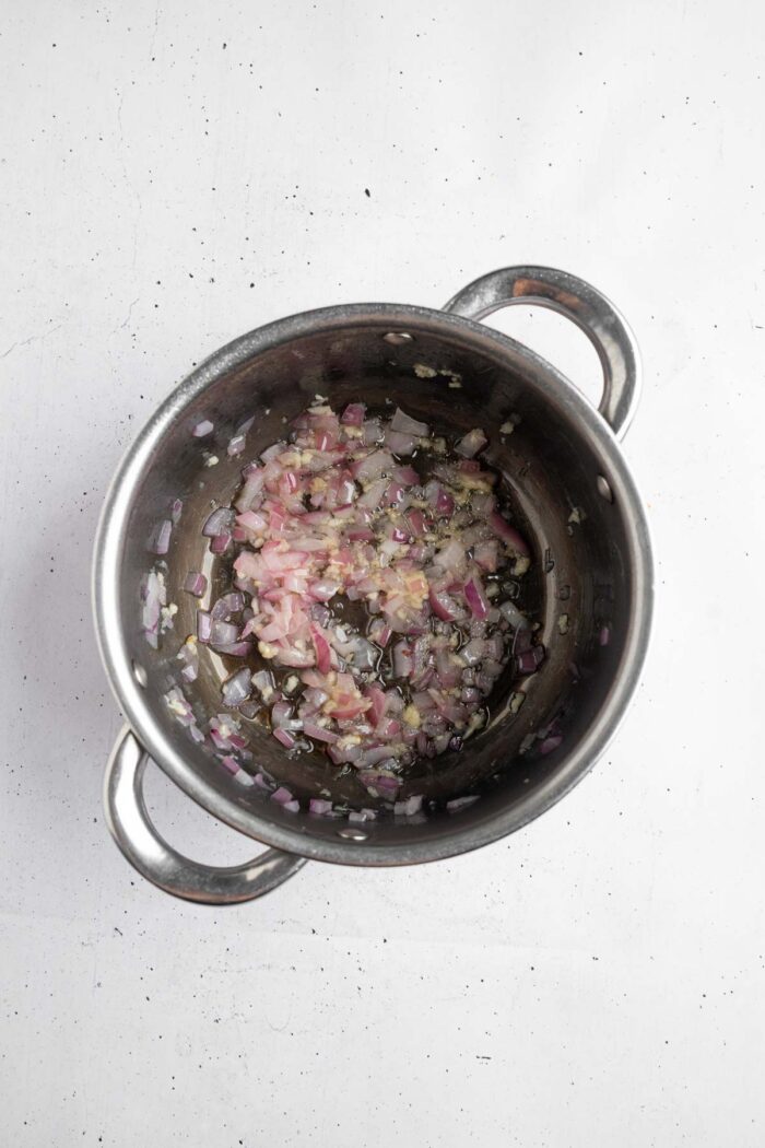 Garlic and red onion sautéed in a steel pan.
