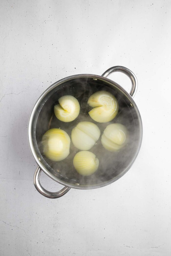 Large onions with a score down the middle in boiling water.