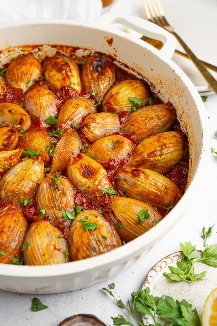 Stuffed onions in a deep baking dish and cooked in tomato sauce.