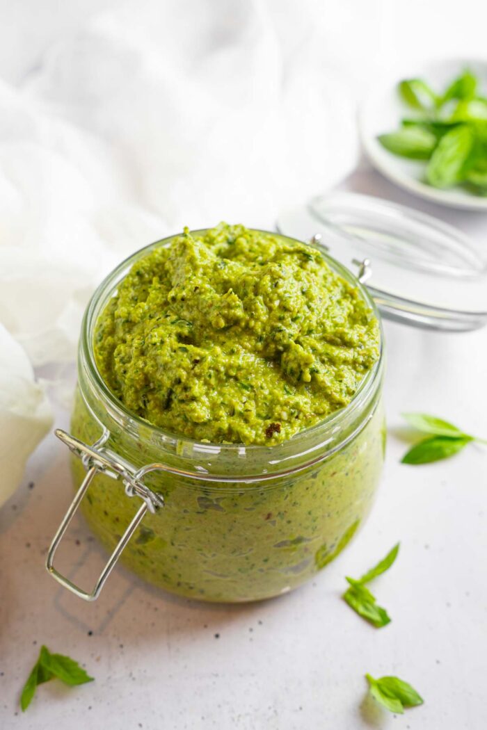 A swingtop mason jar filled to the brim with vegan zucchini pesto.