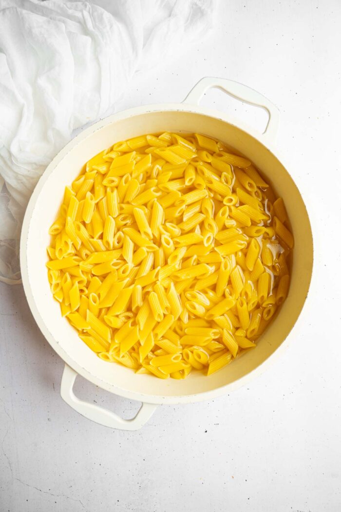 Cooked penne pasta in a large pan.