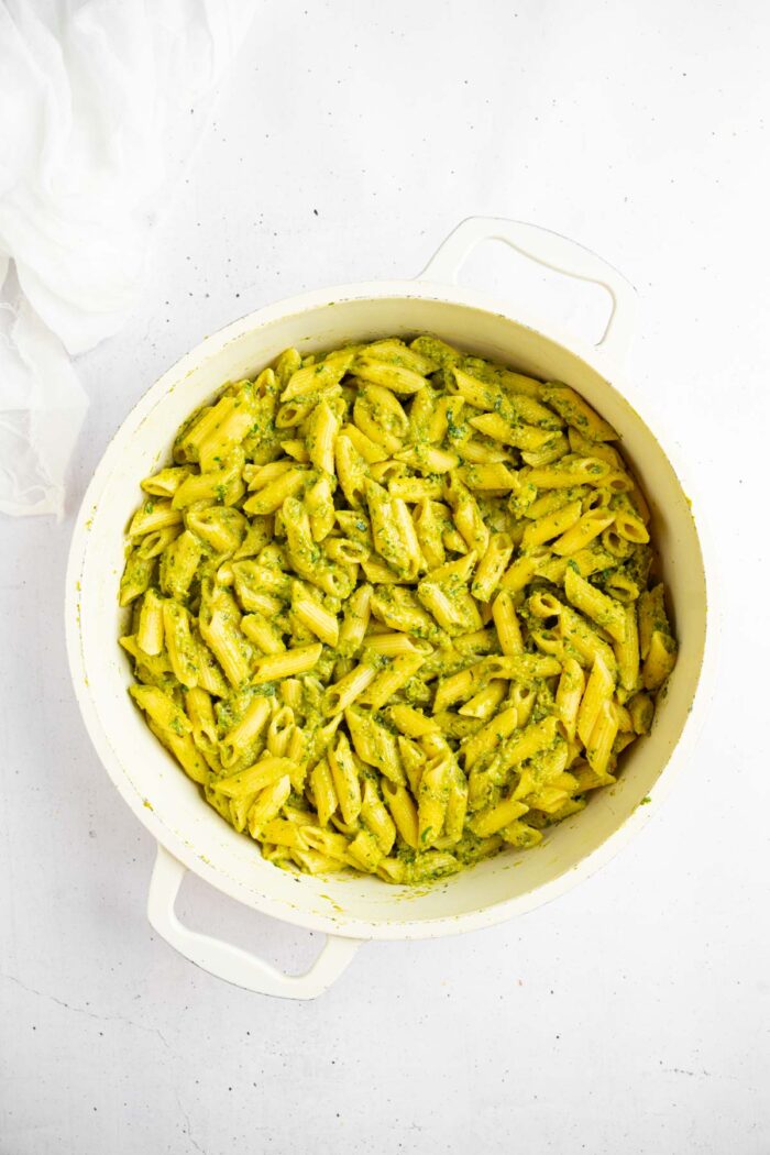 Vegan zucchini pesto mixed with freshly cooked penne pasta.