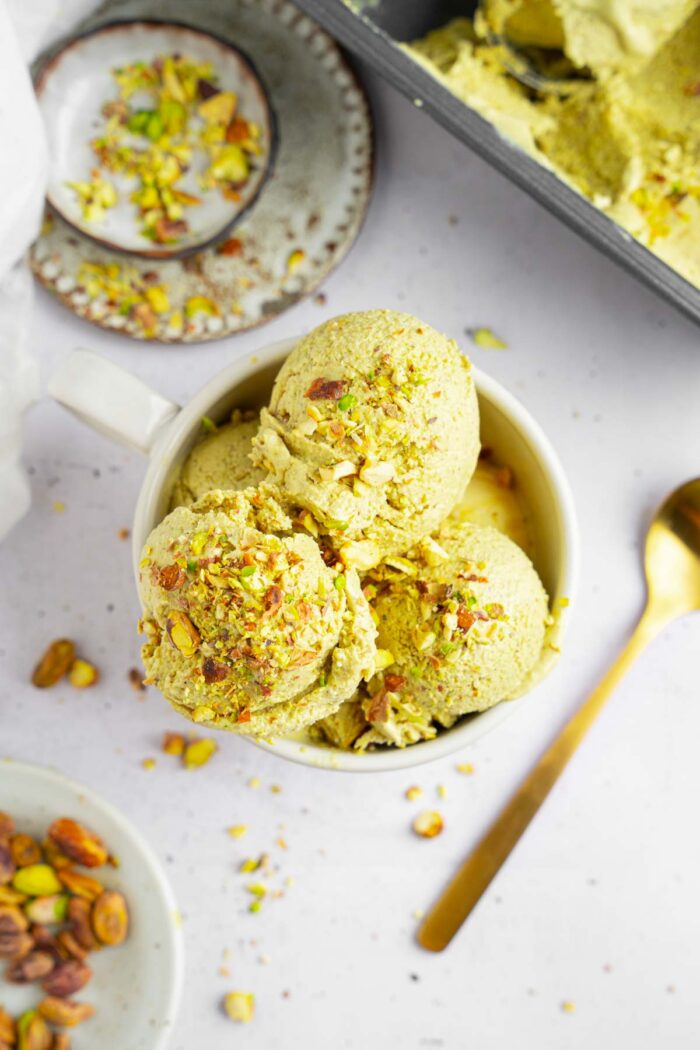 Top down view of the vegan pistachio ice cream scoops in a ramekin.