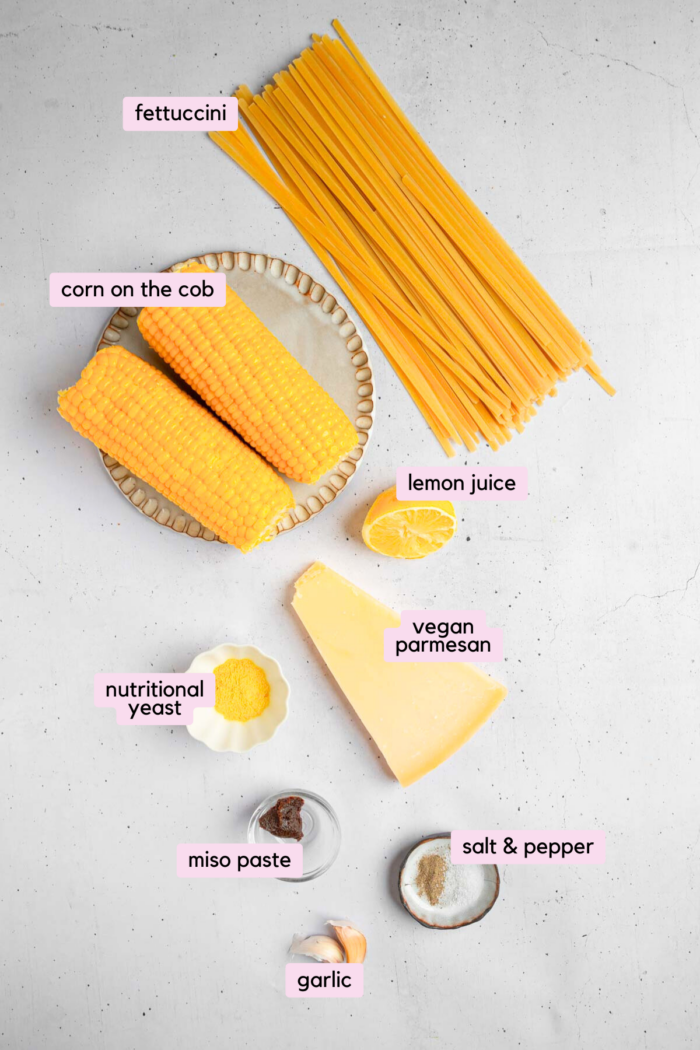 Ingredients required for the creamy corn pasta, laid out and labeled on a light background.