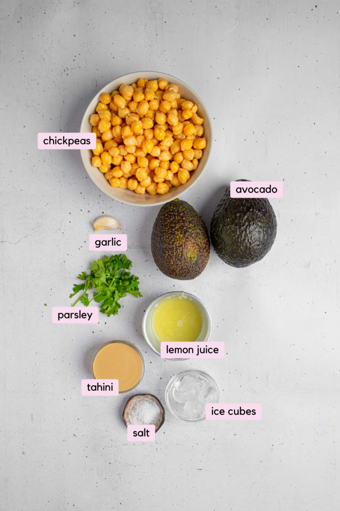 Ingredients for avocado hummus laid out and clearly labeled on a white background.