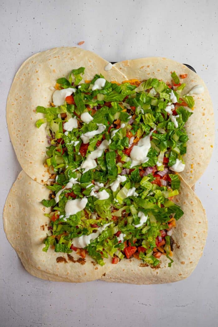 The large sheet pan crunchwrap filling finished off with lettice and vegan sour cream.