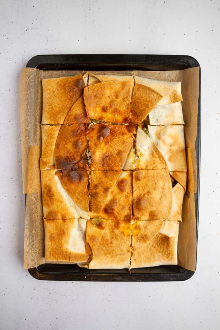 The sheet pan crunchwrap fresh out of the oven, cut into servings.