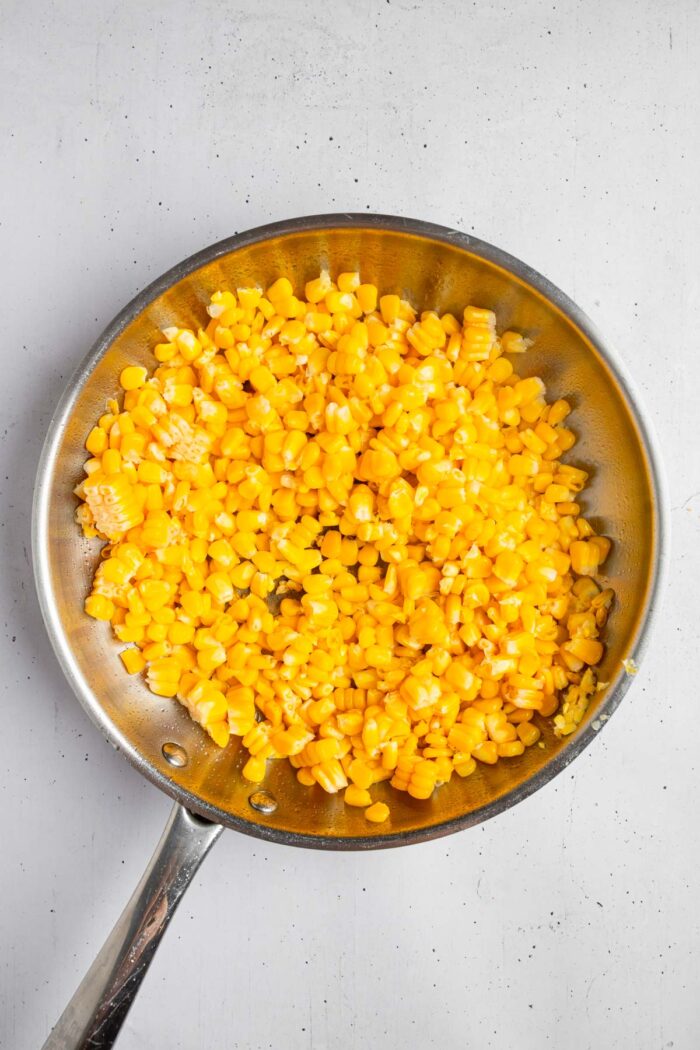 Corn in a large steel pan.