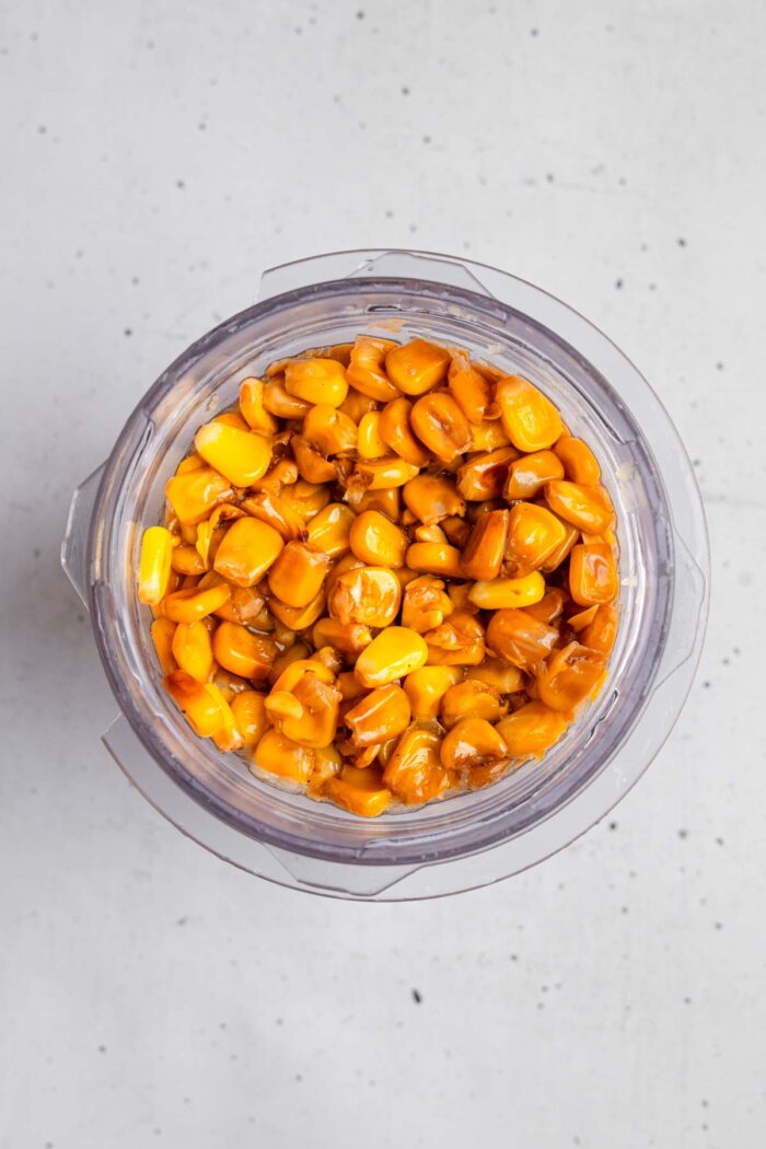 Close shot of seasoned and cooked corn in a blender.