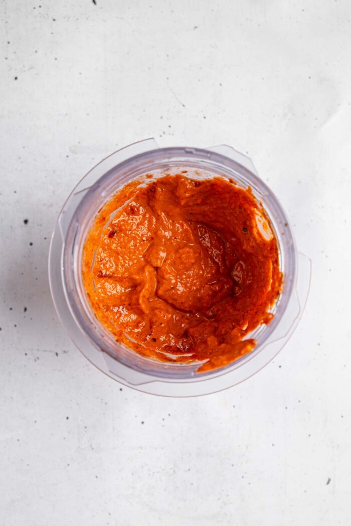 The blended mixture of roasted red pepper walnut dip in a high-speed blender.