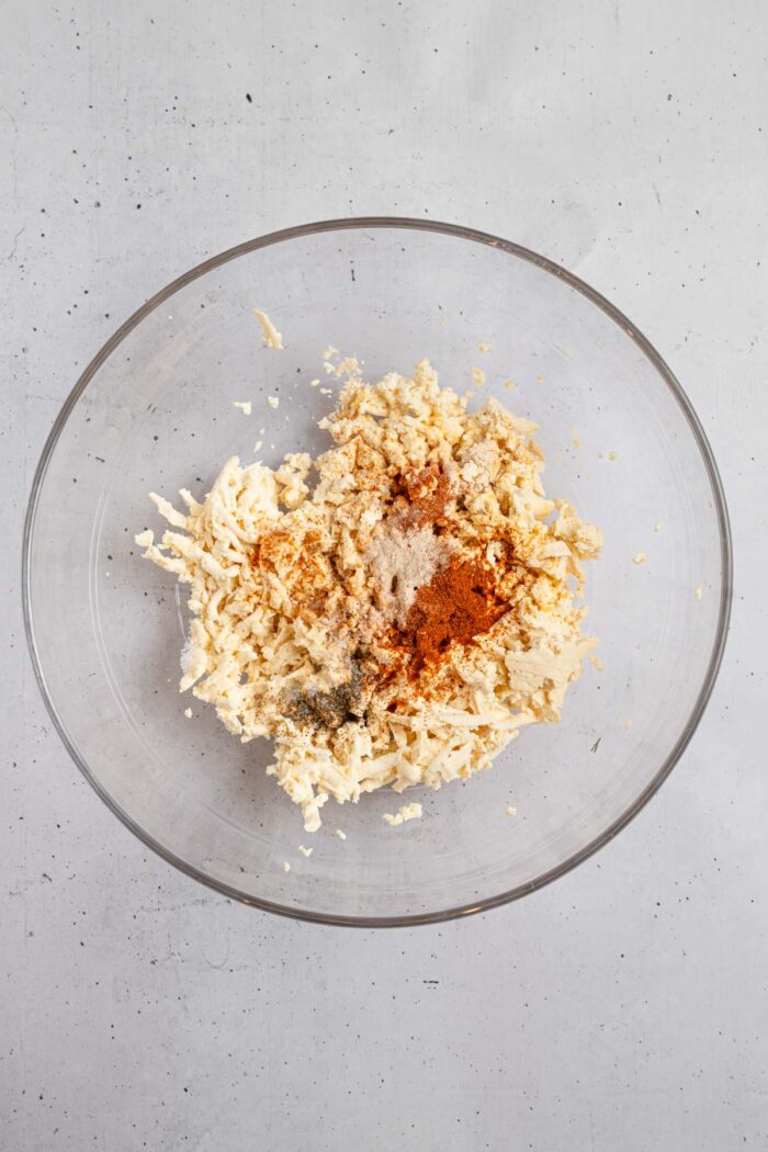 A mixing bowl with grated tofu and seasonings.