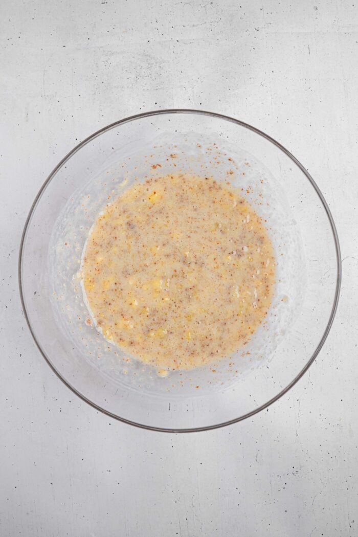 Wet ingredients for banana oatmeal muffins mixed together in a bowl.