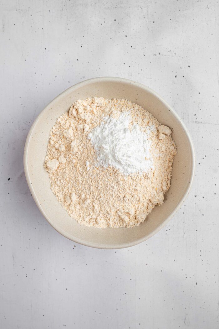 Ground oats (or oat flour) in a bowl with baking powder.