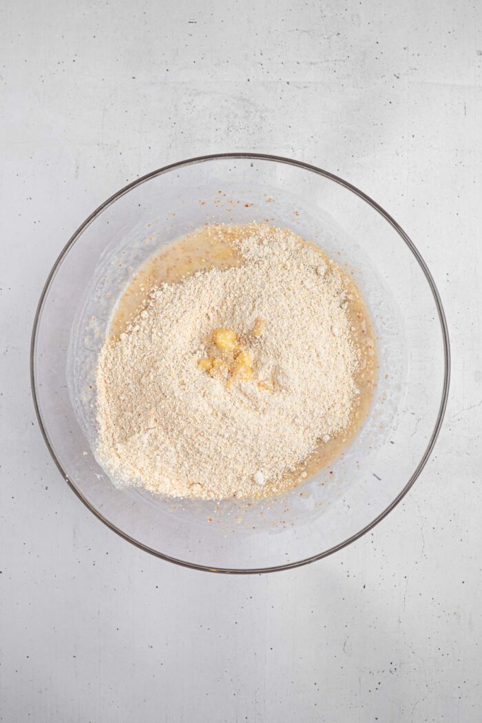 Ground oats (or oat flour) and baking powder added to the bowl with the wet ingredients.