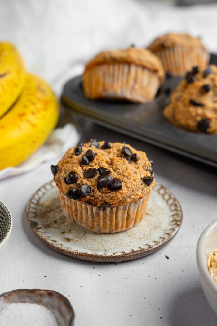 A vegan chocolate chip banana oat muffin served on a dessert plate.