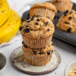 Two banana oatmeal muffins stacked on top of each other on a dessert plate.