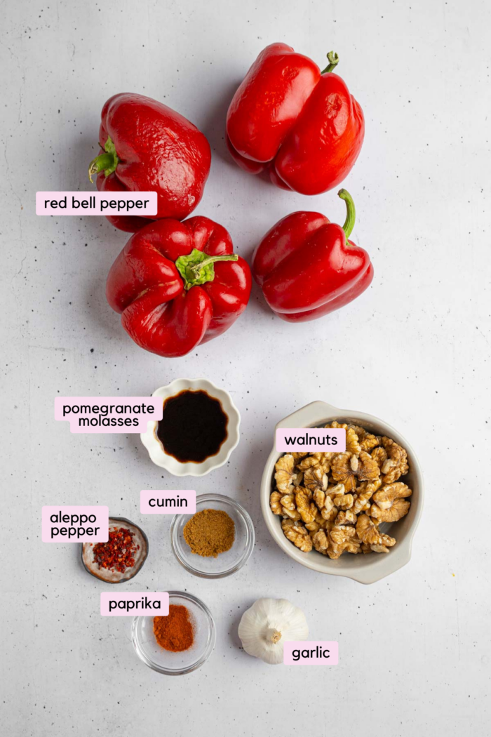 Ingredients for vegan roasted red pepper walnut dip lid out and clearly labeled on a light background.