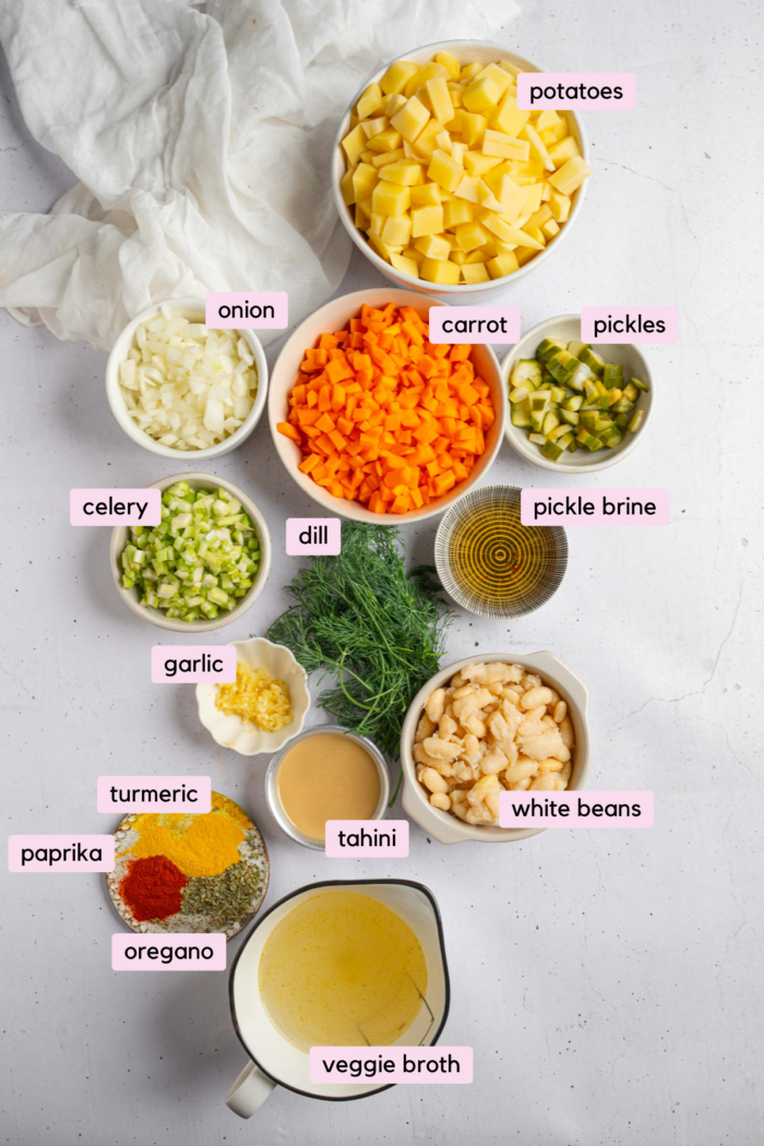 Ingredients for the creamy dill pickle soup laid out and labeled on a light background.