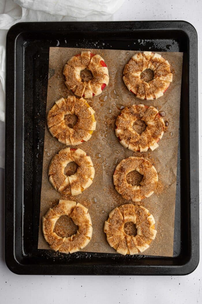Puff pastry apple donuts sprinkled with cinnamon sugar.