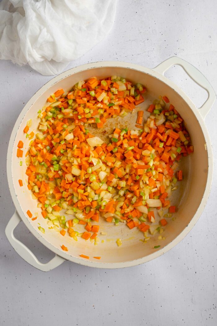 Carrot, onion, and celery base being sauteed in a non-stick pan.