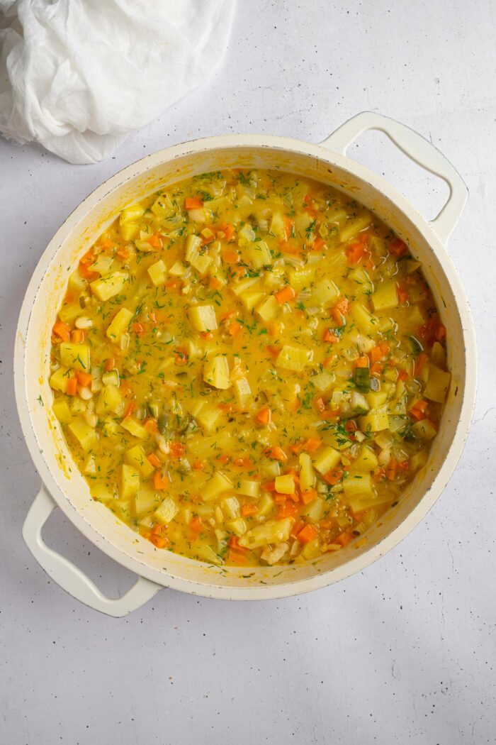 A pot of creamy dill pickle soup freshly from the stove.