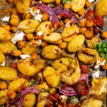 Close up of the mediterranean gnocchi mixture with vegan feta on the baking sheet.