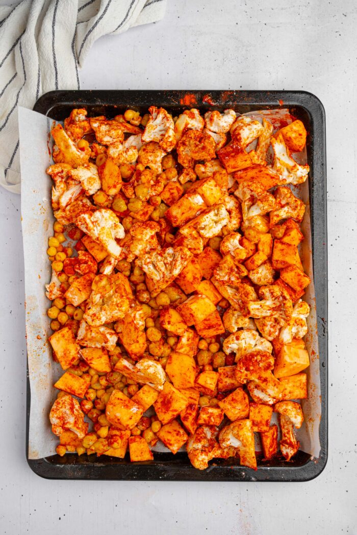 Sweet potato, cauliflower, and chickpeas together with olive oil and spices.