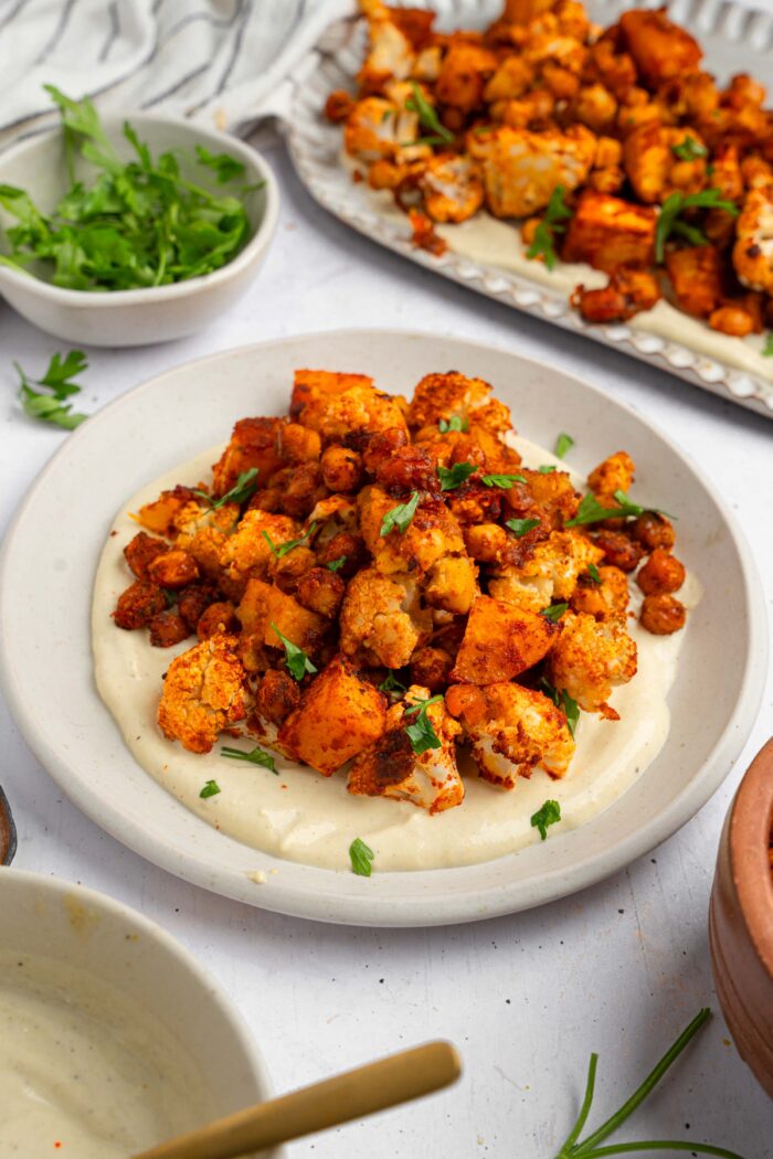 Roasted veggies served on a bed on yogurt maple dressing.