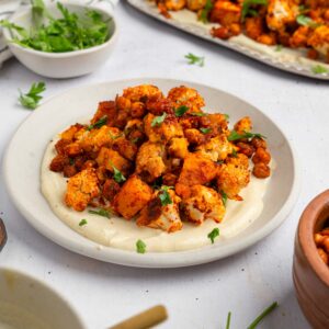A serving of fall sheet pan dinner on a bed of vegan yogurt maple dressing.