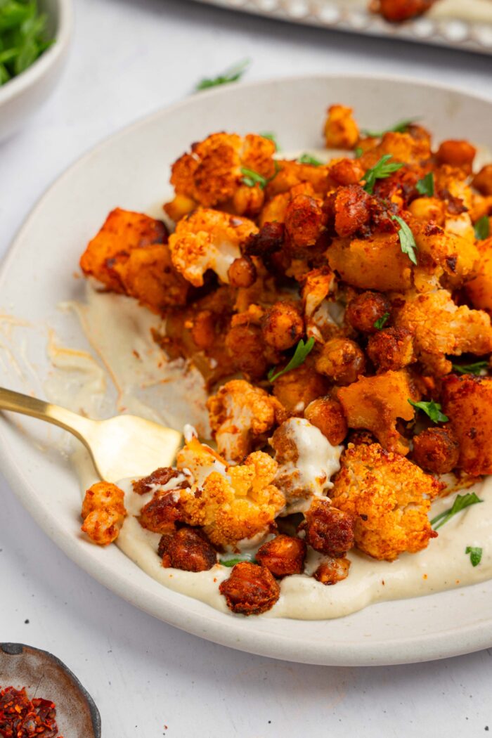 Part of fall sheet pan dinner being scooped with a fork, together with the vegan yogurt maple dressing.