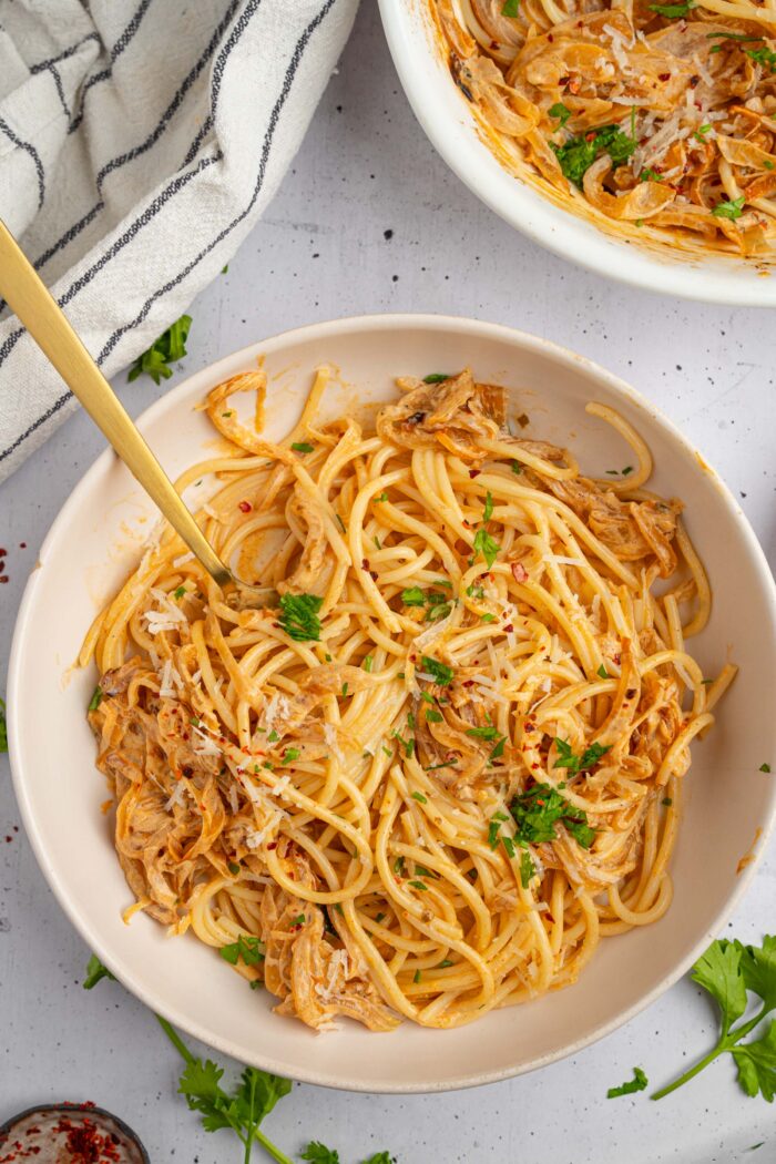 French onion pasta served in a huge ceramic bowl with some fresh parsley and red pepper flakes.