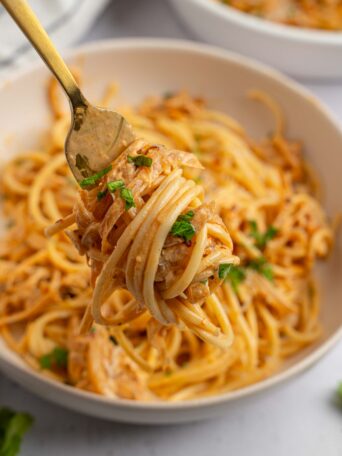 French Onion Pasta wrapped around a fork and lifted up to the forefront.