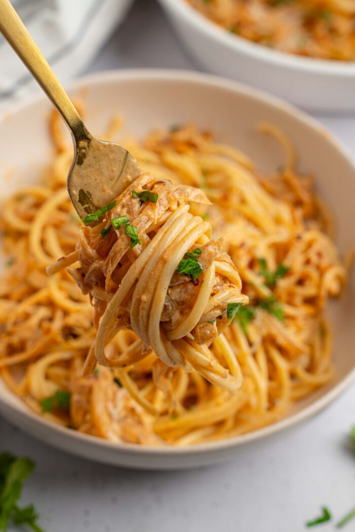 French Onion Pasta wrapped around a fork and lifted up to the forefront.